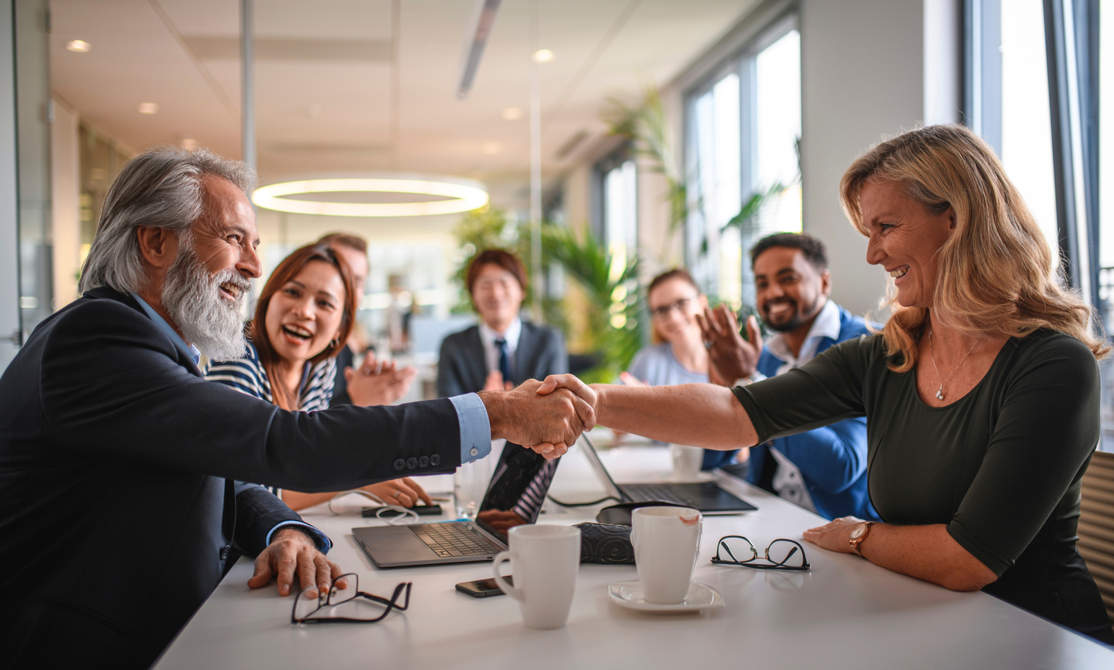 Executive Team Celebrating with Handshake of Success